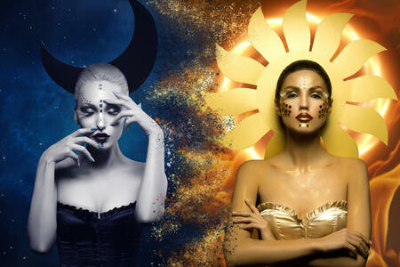 Two beautiful young women dressed as moon and sun girls. Creative styling. Dark star and bright flame background. Copy space.