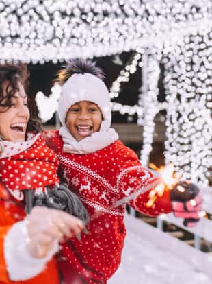 Little black girl enjoying in ice skating with her mother.
