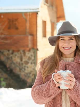 Woman with cup of hot cacao resting at resort