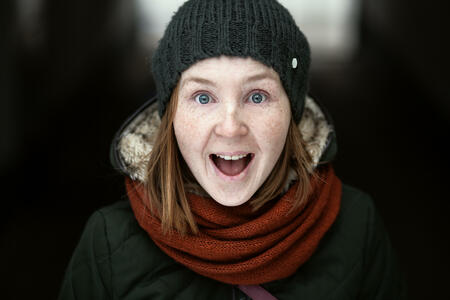 Portrait of playful woman in knitted winter cap smiling