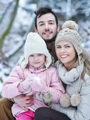 Portrait einer glücklichen Famile mit Tochter im Winter im Schnee