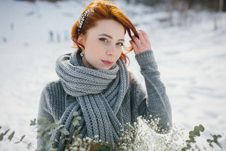 Portrait of a girl dressed in a winter image of the bride. Background winter mountains and forest