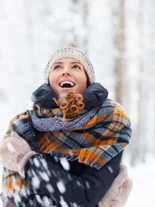 Waist up portrait of beautiful young woman in winter forest having fun and enjoying snow, copy space