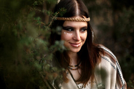beautiful native indian american woman with warrior shaman make up on background of woods