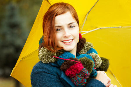 Fashion portrait of a beautiful young woman in autumn forest. Girl with umbrella