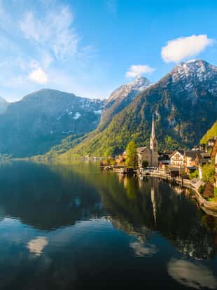 Scenic nature landscape view of Hallstatt mountain village reflecting in Hallstatter see lake against The Austrian Alpines in with morning sunshine and beautiful blue cloudy sky looking like a postcard picture in Salzkammergut region, Austria xxxl size april 2017