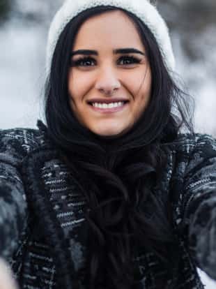 A smiling girl in a park in winter looking at camera