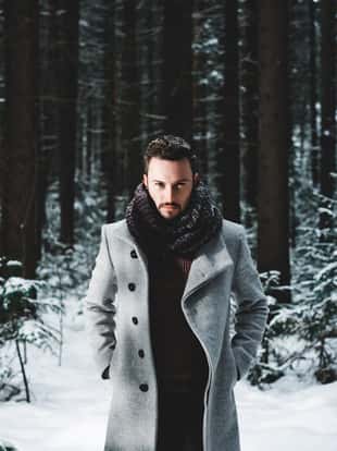 Outdoor portrait of handsome man in coat and scurf. Casual winter fashion