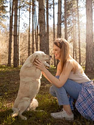 Woman with golden retriever in park