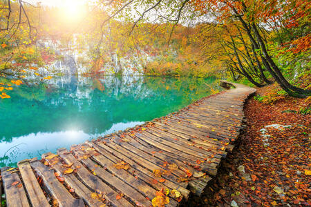Famous tourist wooden pathway in the colorful deep forest with clean lake, Plitvice National Park, Croatia, Europe