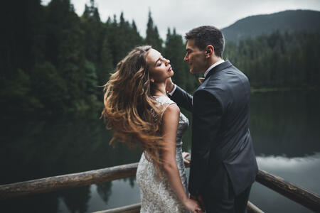 Happy wedding couple posing over beautiful landscape in the mountains.