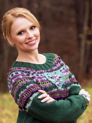 Woman posing in autumn park in a green knit sweater