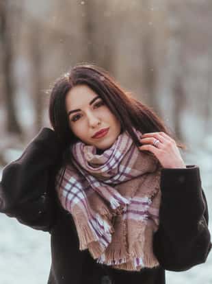Young beautiful model posing in winter forest