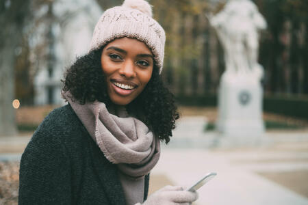 Young black woman on the mobile phone near the royal palace in winter