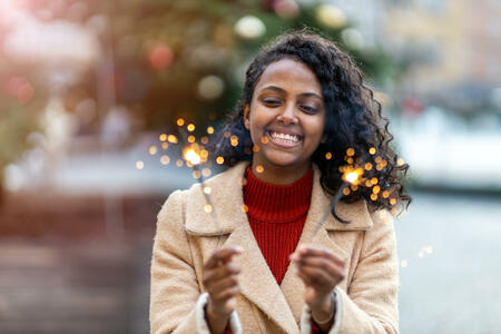 Happy woman at Christmas holding burning sparkler
