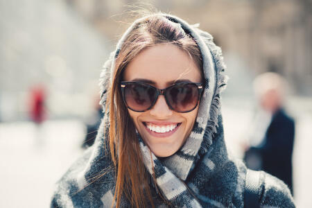 Young woman wrapped in scarf smiling to the camera