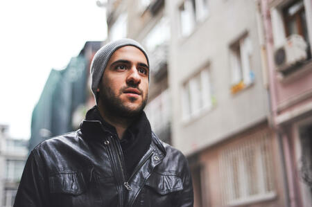 portrait of a young middle-eastern man wearing a leather jacket, outdoors