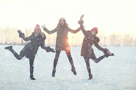 young women walking and having fun in the winter in the snow field