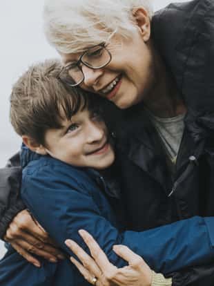 Happy grandmother hugging her grandson