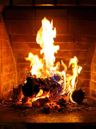 Autumn or winter burning fireplace cozy evening concept close up