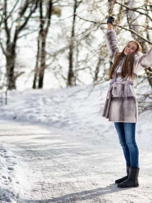 Beautiful woman walking in winter forest and have funBeautiful happy woman walking in the winter forest