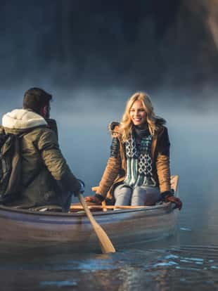 Couple enjoying a winter canoe ride on the lake.