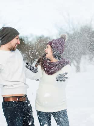 A Pregnant couple have fun in winter nature