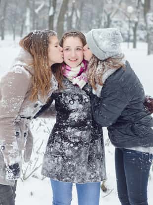 Teenage girlfriends having fun in the winter snow.