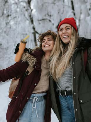 Two female friends are having fun on a snowy winter day.