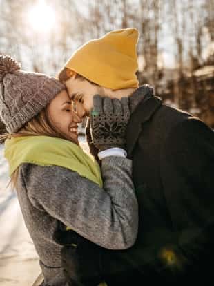 Young couple having good time on sunny winter, enjoying in snow
