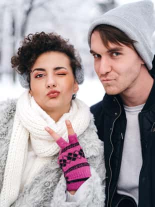 Young couple posing and gesturing for camera in the snow