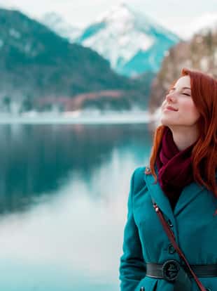 Young redhead girl in coat near lake in Alps, Germany