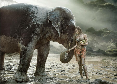 Sensual young tamer feeding her elephant pet