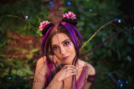Fantastic photo shoot.  Fairy Coquette standing near the huge mushroom. Portrait, fairy looks into the camera  her huge, beautiful eyes. The unusual fairy-tale image, purple dress and torn wings. Fashionable toning.