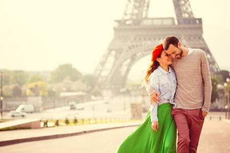 Young loving couple sharing their love and affection in front of the Eiffel tower in Paris, France.