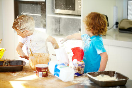 Little boys covered in baking ingredients during a messy baking session