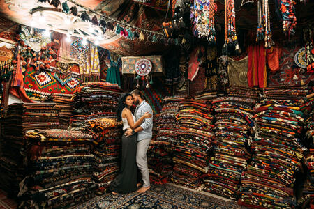 Happy couple in the Eastern country. Man and woman in the store. Couple in love in Turkey. Happy couple travels the world. Persian shop. Tourists in store. Oriental carpet. Istanbul. Holiday in Turkey