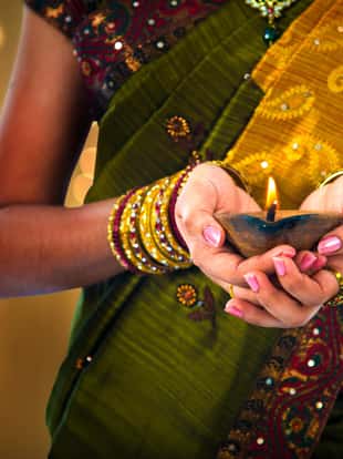 diwali or deepavali photo with female holding oil lamp during festival of light