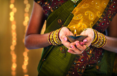 diwali or deepavali photo with female holding oil lamp during festival of light