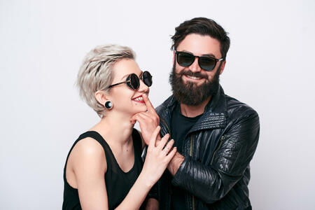 Hipster love concept. Stylish fashion couple in trendy fashionable clothes in studio over white background