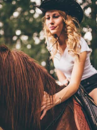 Beautiful girl riding a horse in countryside o na nice summer day