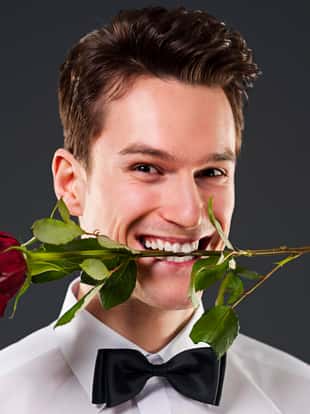 Man with a red rose in mouth