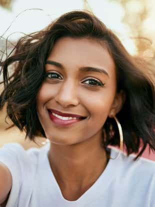 Cropped portrait of an attractive young woman standing against her car and taking a selfie alone during a day out