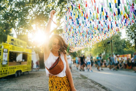 Young Caucasian woman in yellow skirt having fun on music festival in summer