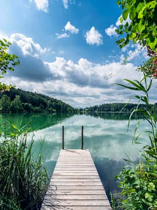 Austria, upper austria, Hoellerersee. The Hoellerer See is a body of water in Upper Austria in the area of the municipalities of St. Pantaleon and Haigermoos. It is 780 m long, 330 m wide and has the shape of a kidney; the maximum depth is 21 meter.