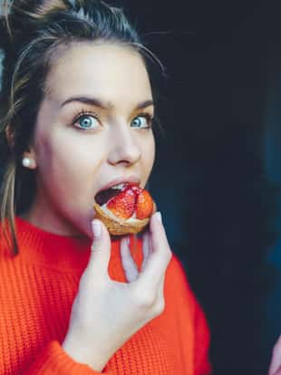 Hungry woman eating secretly sweet dessert