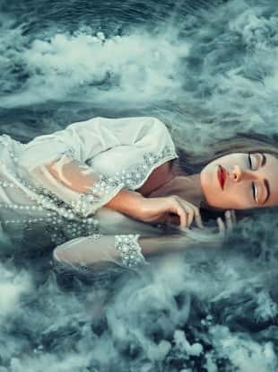 Fairy lying in the water, shrouded in mist. Fashionable toning