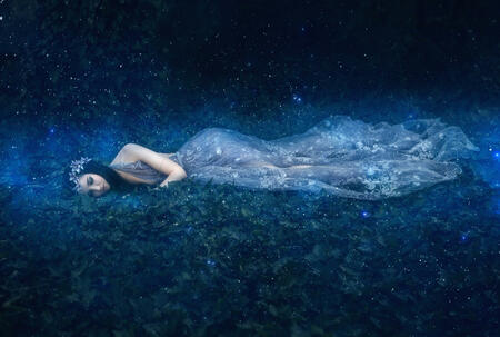 Beautiful young girl sleeps in the arms of space among the stars , fantasy fotoshoot , fashionable toning , creative color