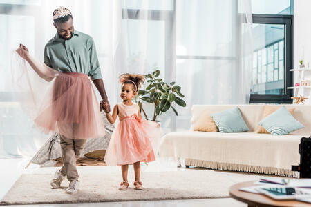 happy african american father in cute pink tutu and adorable daughter in beautiful dress