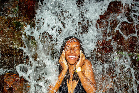 Very Happy Black Woman Bathing in a beautiful waterfall that is in Brásilia, capital of Brazil, in UNIPAZ